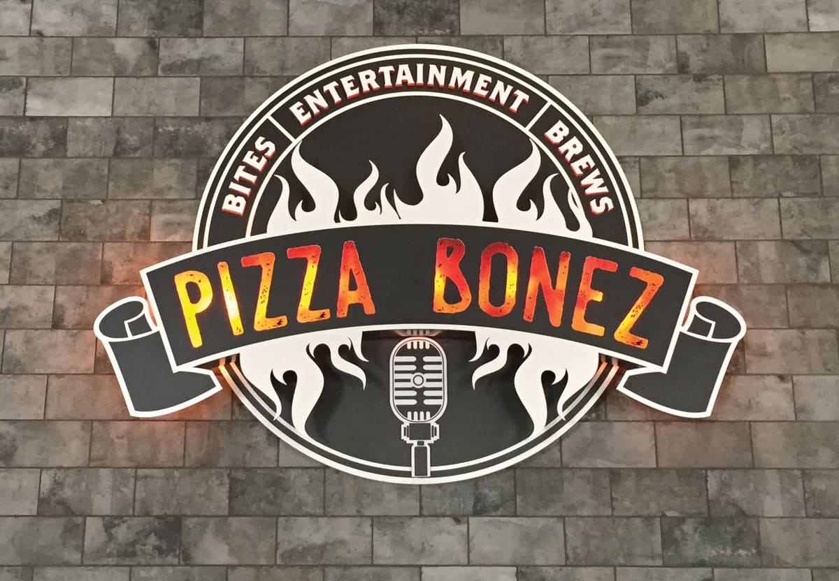 Pizza Bonez backlit dimensional logo sign on an interior stone wall